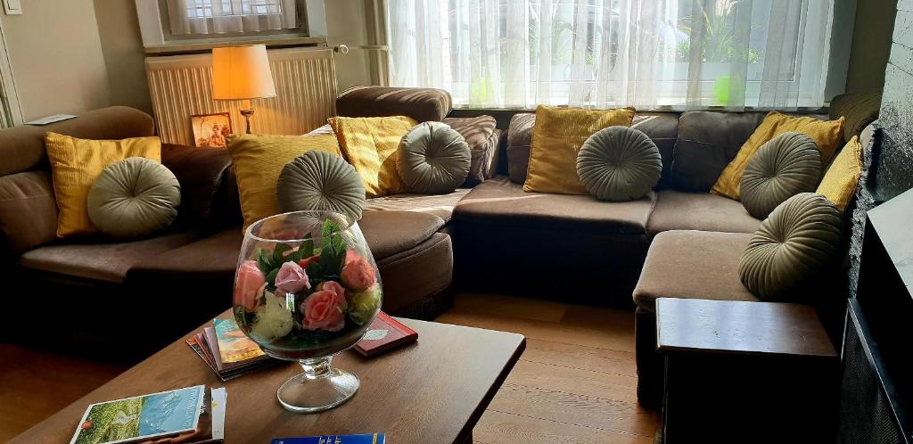 un soggiorno con divano e tavolo con bicchiere di vino di R&breakfast a Roeselare