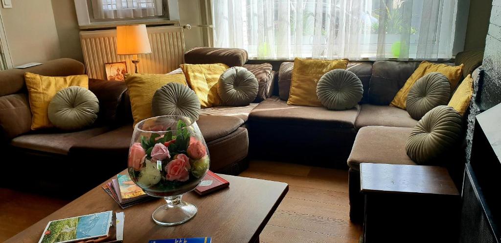 a living room with a couch and a table with a wine glass at R&breakfast in Roeselare