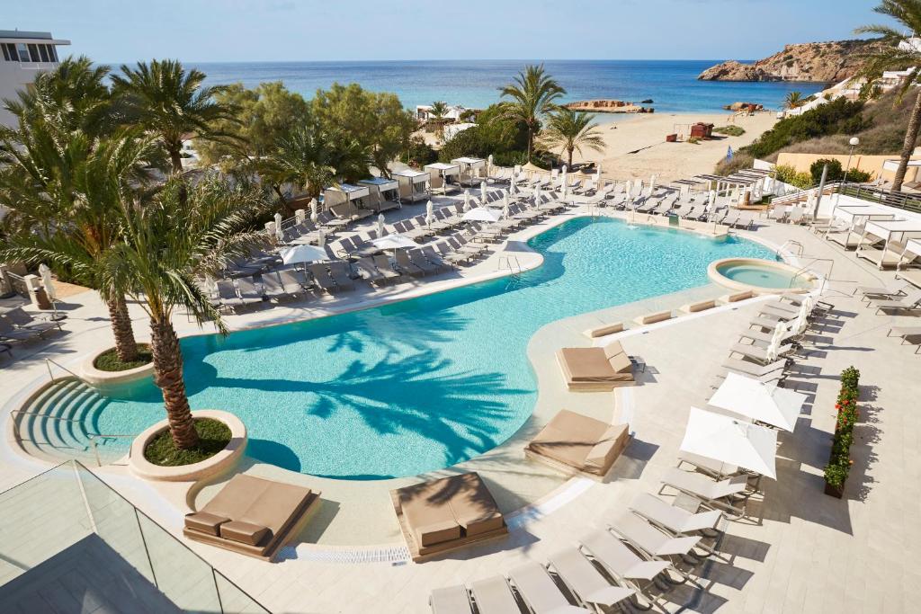 an aerial view of a resort with a pool and chairs at Insotel Tarida Beach Resort & SPA in Cala Tarida