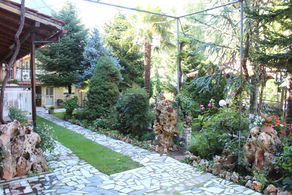 a garden with a stone walkway in a yard at Germanos Studios in Kato Loutraki