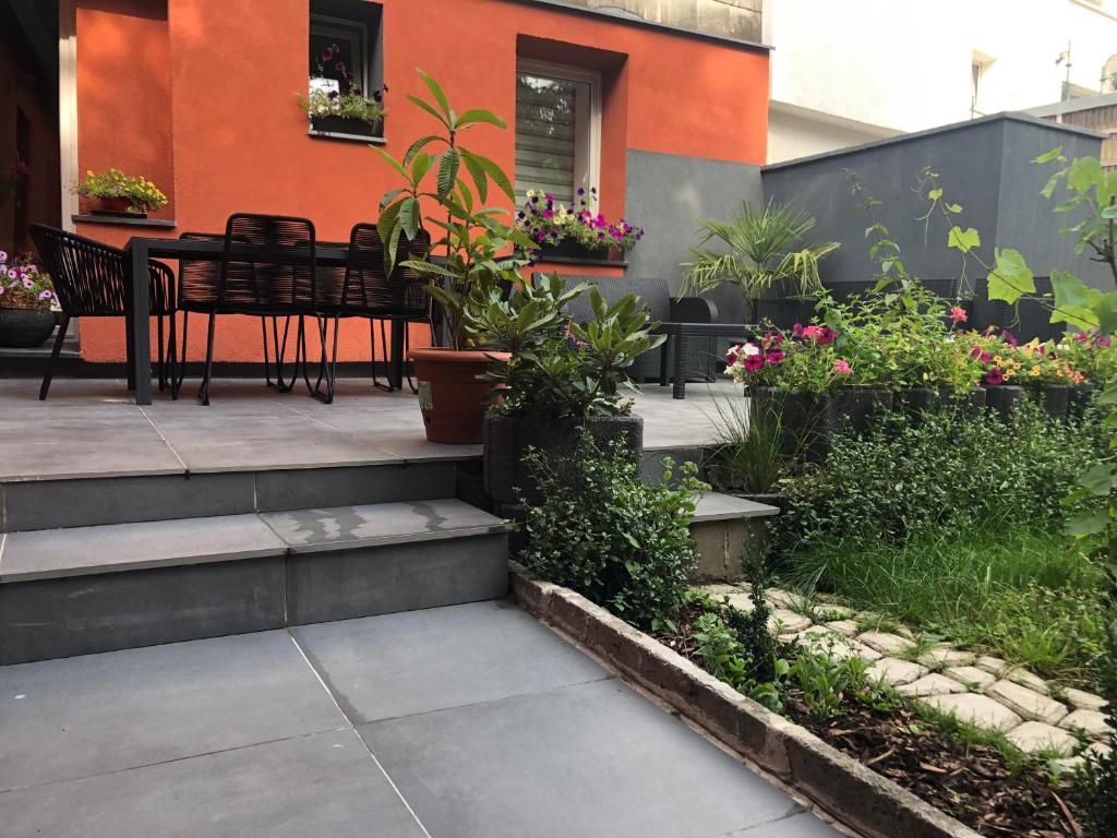 un patio con tavolo, sedie e fiori di VIP 67 a Eupen