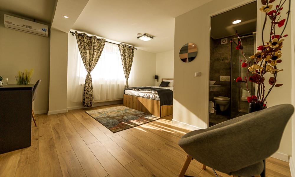 - une chambre avec un lit, une fenêtre et une chaise dans l'établissement Casa Bella, à Hunedoara