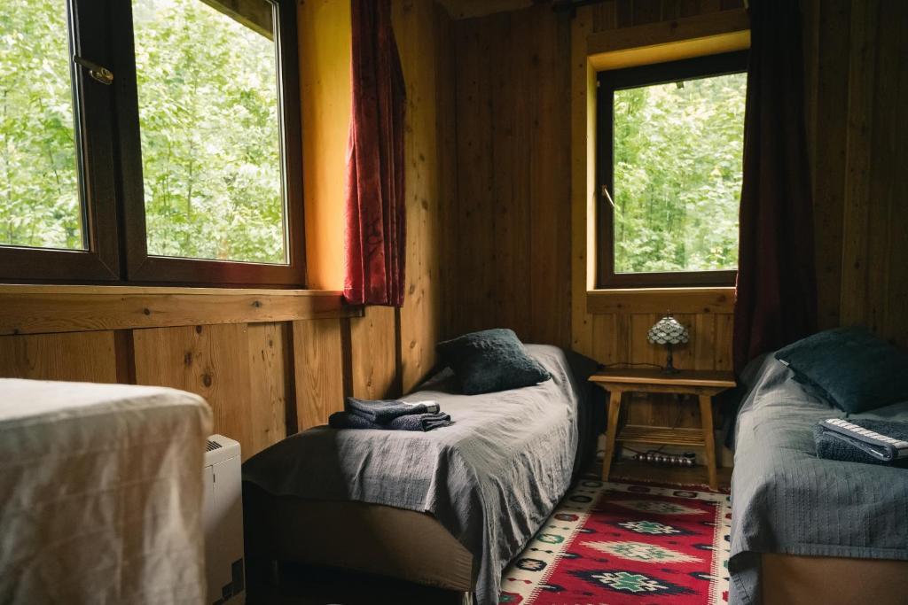 a small room with two beds and two windows at Domalek pod Złotym Kogutem in Kudowa-Zdrój