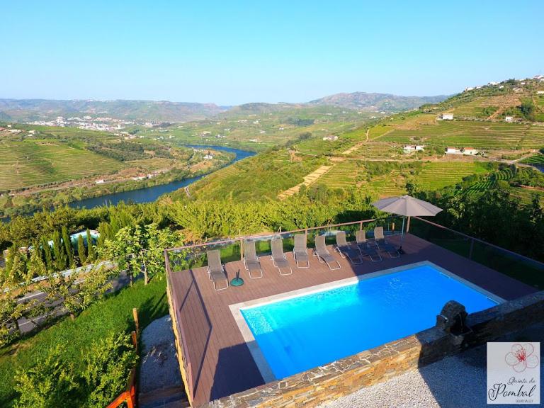 an overhead view of a pool with chairs and an umbrella at Quinta do Pombal Douro in Penajoia