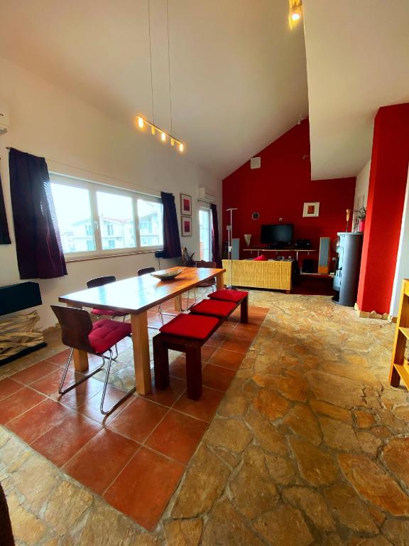 a living room with a wooden table and red walls at Modern Red & Blue Apartment in Podstrana