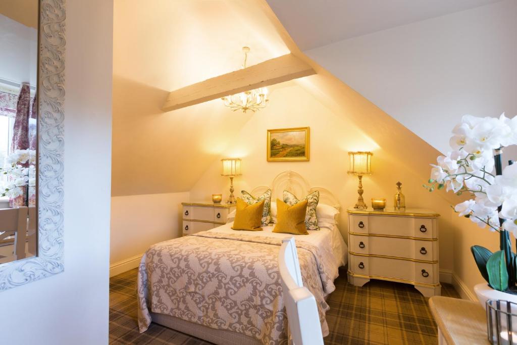 a bedroom with a bed with yellow walls at Warkworth House Hotel in Warkworth
