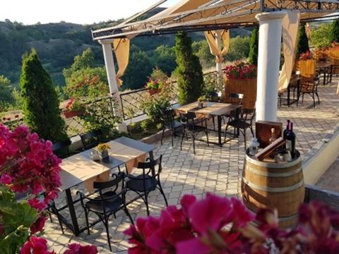 un patio con mesas y sillas y un ramo de flores en Boutique Hotel Colosseo en Sandanski