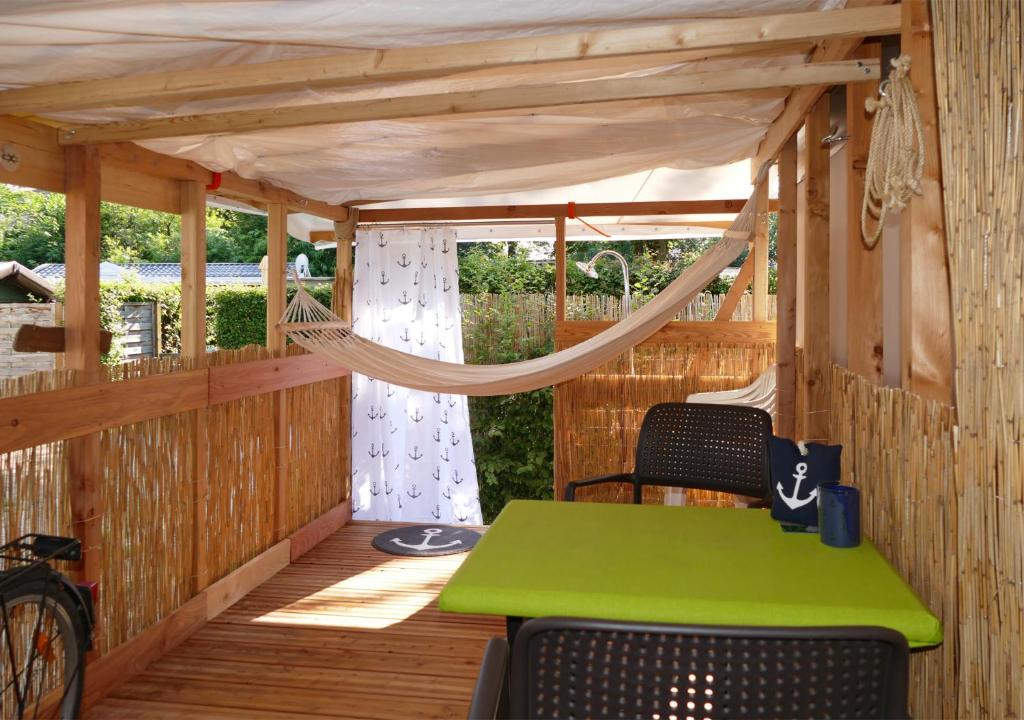 porche con hamaca, mesa y sillas en Refugio del Lago, en Seekirchen am Wallersee