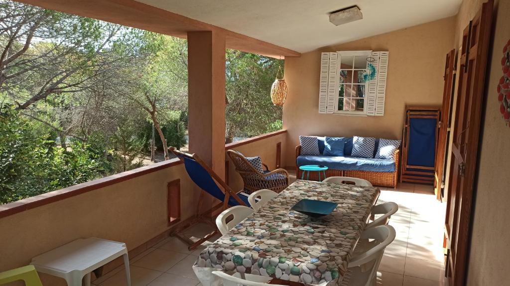 a balcony with a table and chairs and a couch at Sa Prama Pineta in Orosei