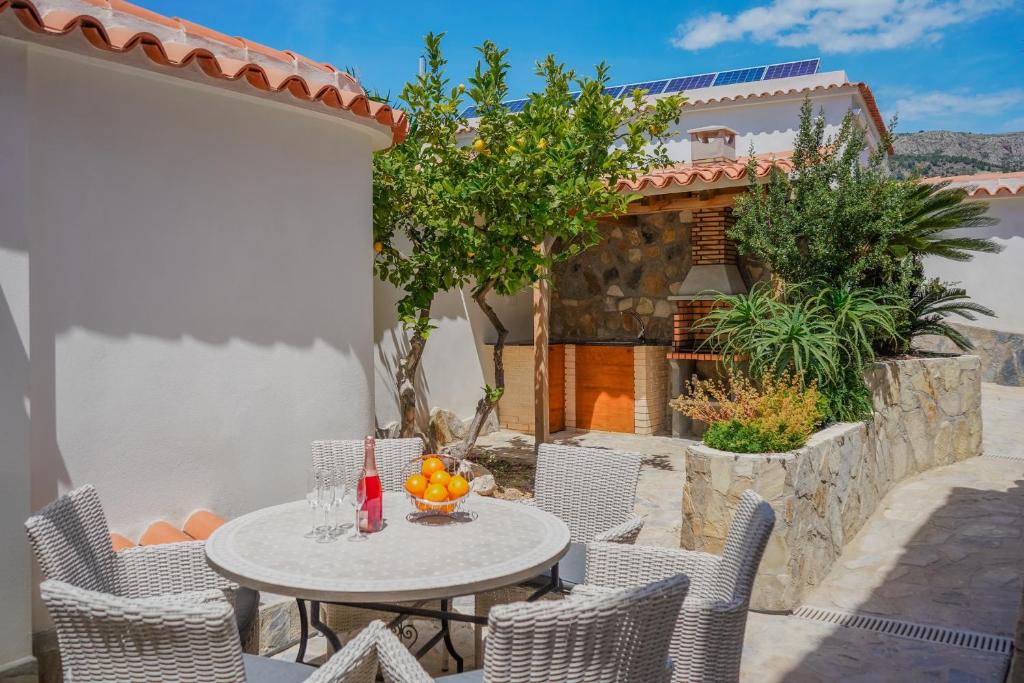 a patio with a table and chairs and a house at Maryvilla Inspiración y Vacaciones - Bungalows in Calpe
