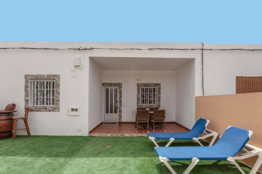 a patio with two blue chairs and a table at Casa Yamile in Tarajalejo