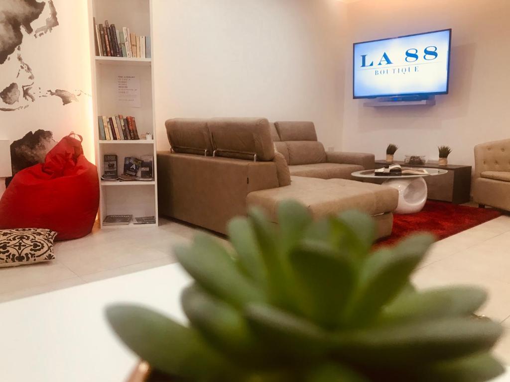 a living room with a couch and a tv at LA 88 Boutique in St Paul's Bay