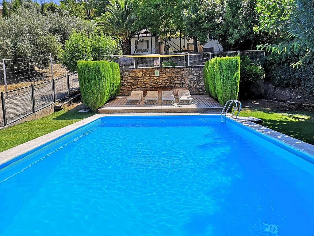 a large blue swimming pool in a yard at Casa el Rincon Cazorla in Burunchel