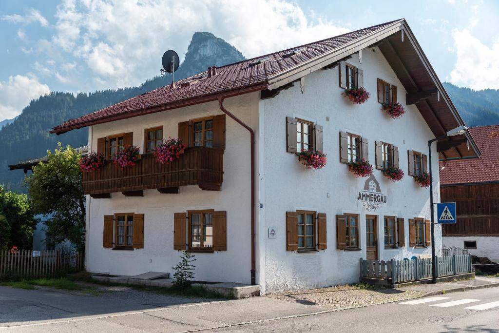 un edificio blanco con ventanas y cajas de flores. en Ammergau Lodge, en Oberammergau