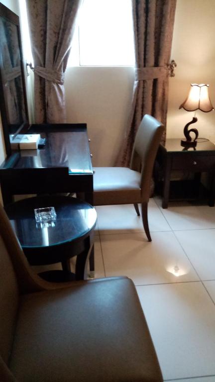 a living room with a desk and a chair at Paragon Hotel Apartments in Abu Dhabi