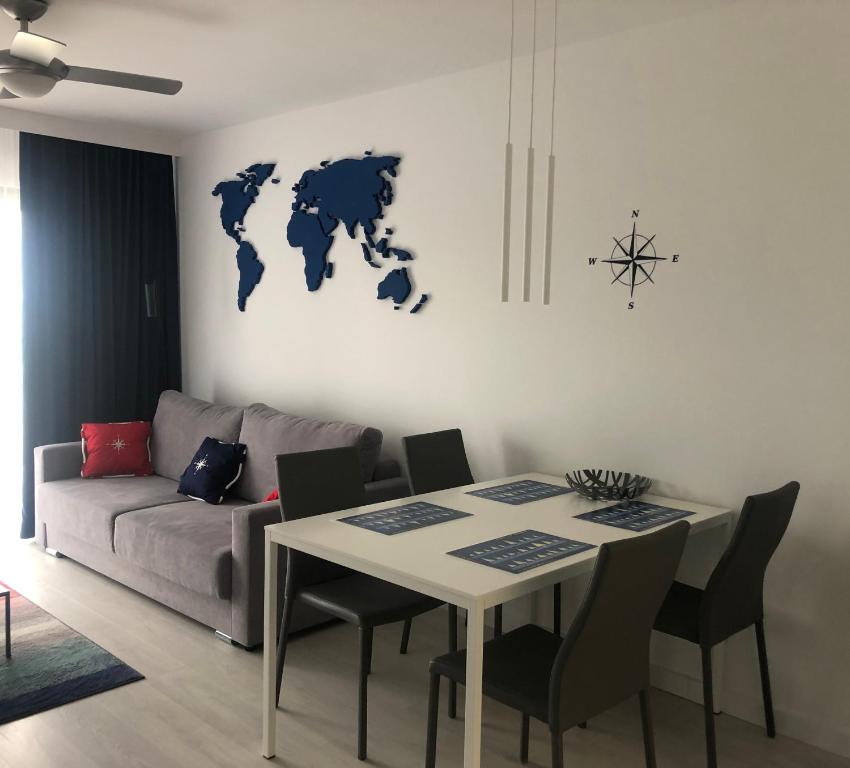 a living room with a table and a couch at Apartamenty Morskie Gardenia 2 in Dziwnów