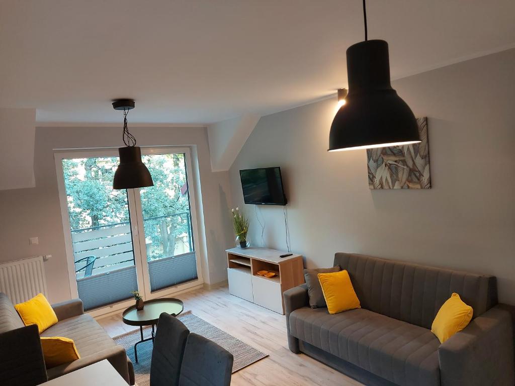 a living room with a couch and yellow pillows at Apartament Snow White in Karpacz