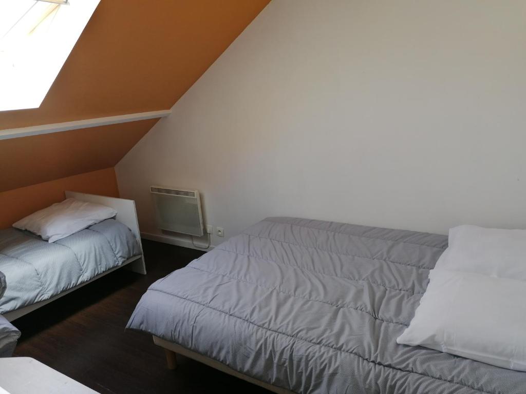 a attic bedroom with two beds and a television at Le sacré cœur bis -duplex 5pl in Le Havre