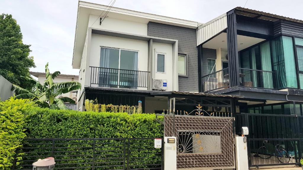 a house with a fence in front of it at NIDO Guest House in Ban Bang Phang