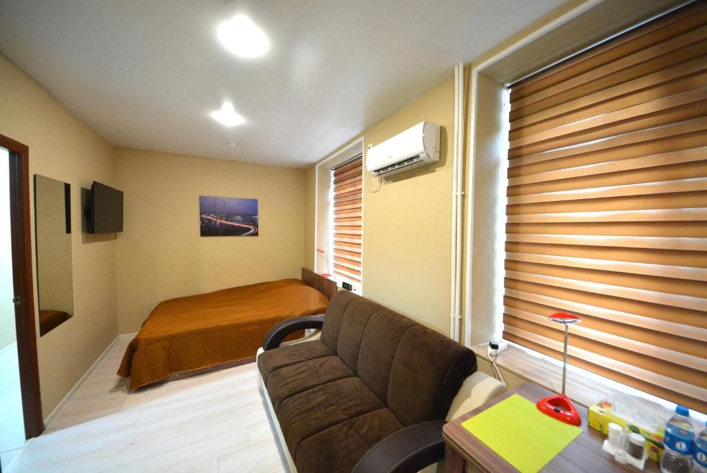 uma sala de estar com um sofá e uma cama em Aloha Capsule Hotel em Vladivostok