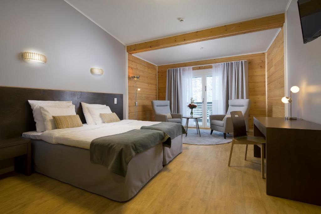 a bedroom with a large bed and a desk at Rento Hotelli in Imatra