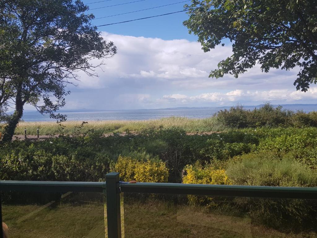 a view of the ocean from the porch of a house at Sea views, fabulous modern lodge in Port Seton
