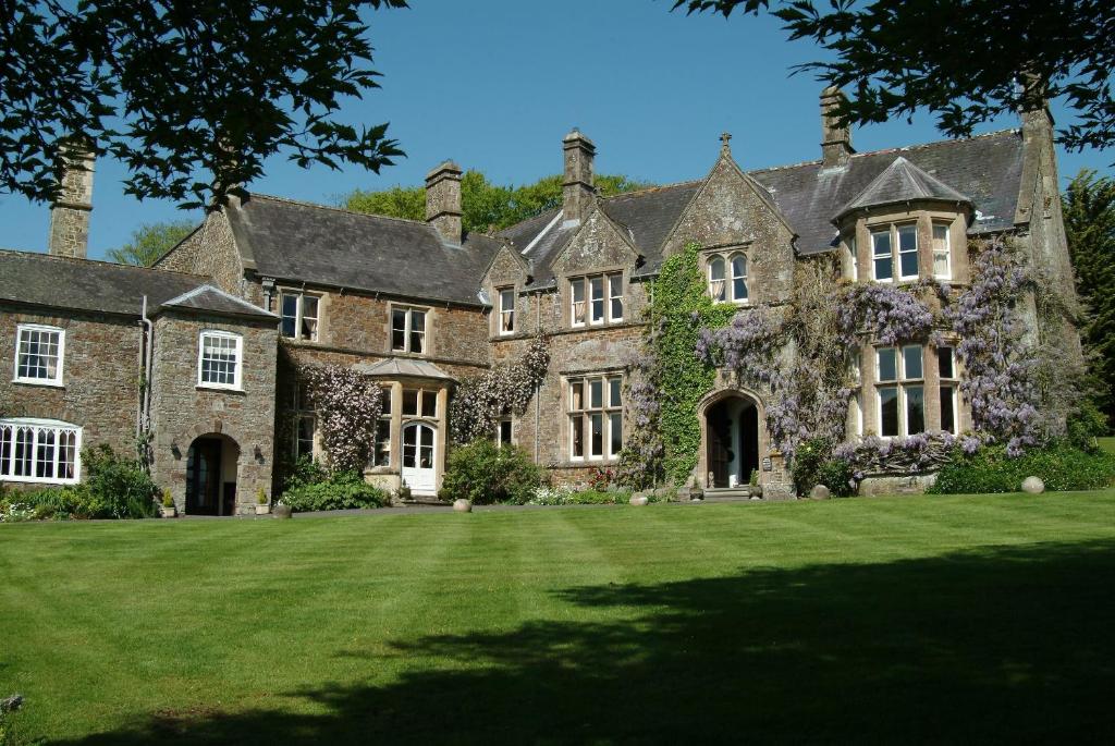 an old stone house with a large yard at Northcote Manor in Umberleigh Bridge