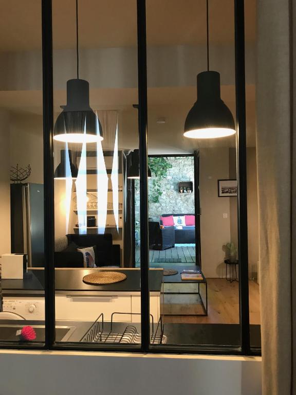 a kitchen with two pendant lights and a living room at T2 centre ville avec extérieur in Avignon