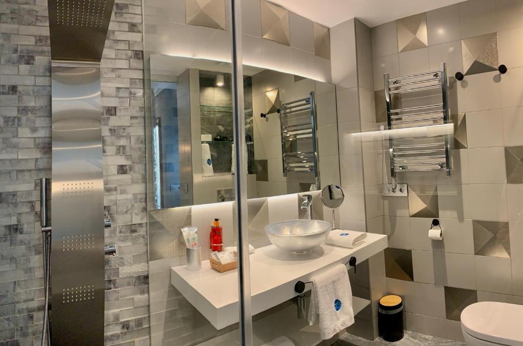 a bathroom with a sink and a glass shower at Mamma Mia Hotel Boutique - Only Adults in Tossa de Mar