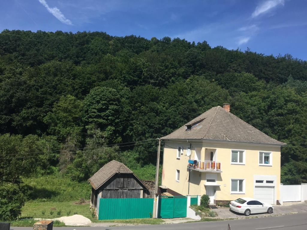 a house and a car parked in front of a mountain at Rekreacny dom pod Bezovcom in Stará Lehota