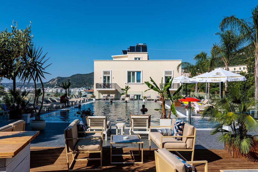 um resort com piscina e cadeiras e um edifício em Le Palazzine Hotel em Vlorë