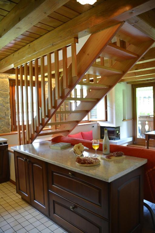 a kitchen with a staircase and a table with glasses of wine at Pa' Eimbdlar in Sauris