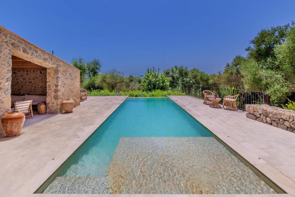 a swimming pool in a backyard with a wooden deck at Villa Can Suau Petit by Sealand Villas in El Port