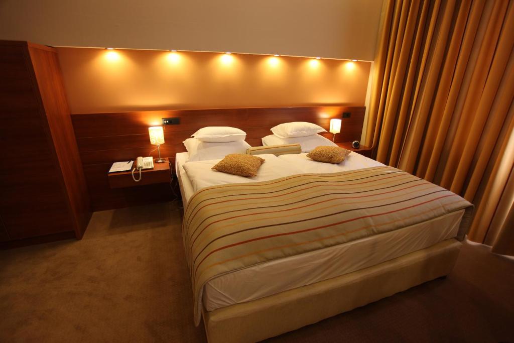 a hotel room with a large bed with lights on it at Hotel Central in Vitez