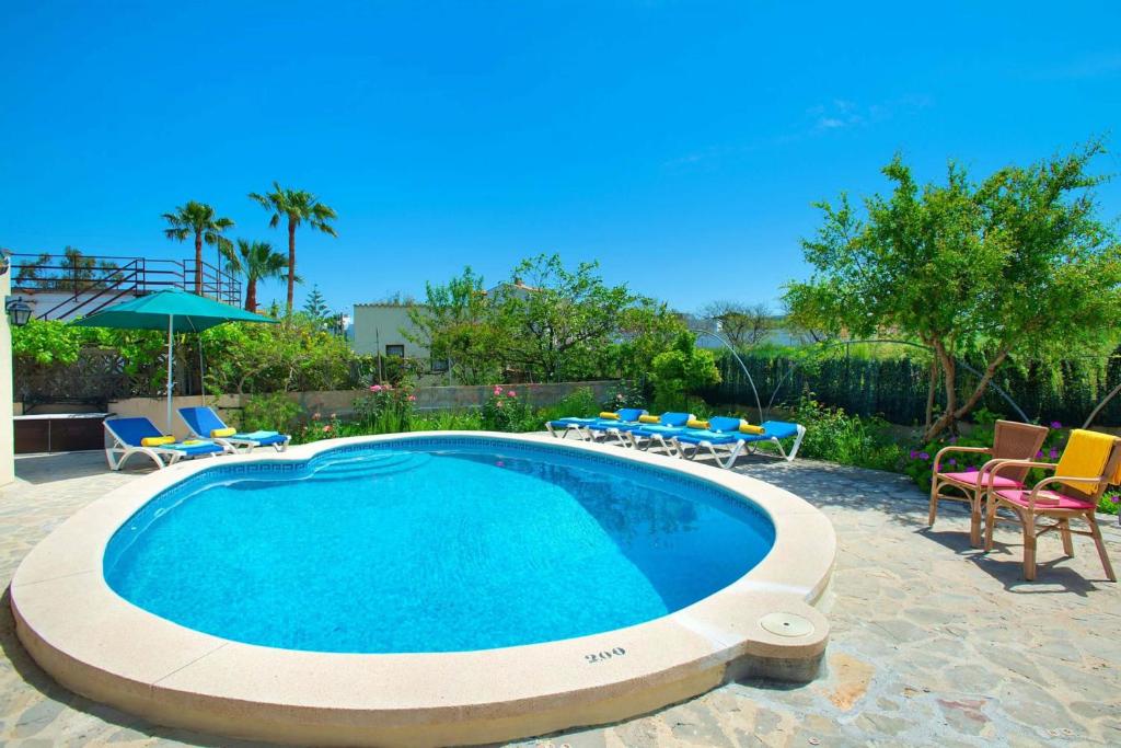 a large swimming pool with chairs and a table at Villa Tomeu by Sealand Villas in Port de Pollensa