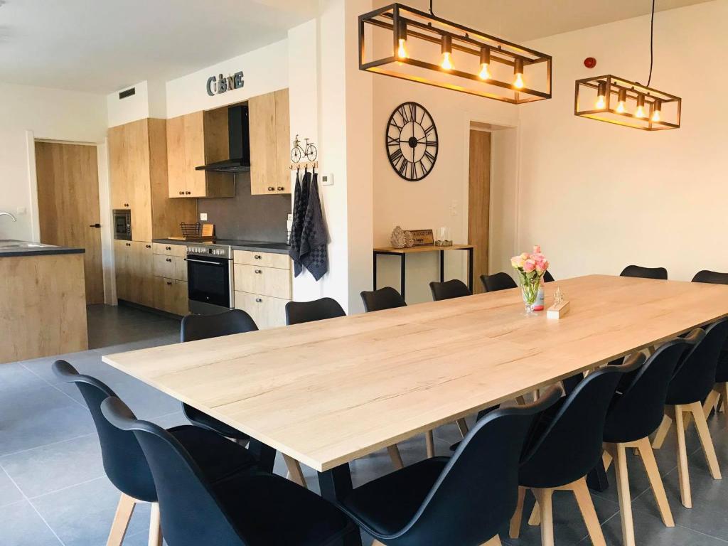 una gran mesa de madera en una cocina con sillas en Vakantiewoning d'Hoppe en Flobecq