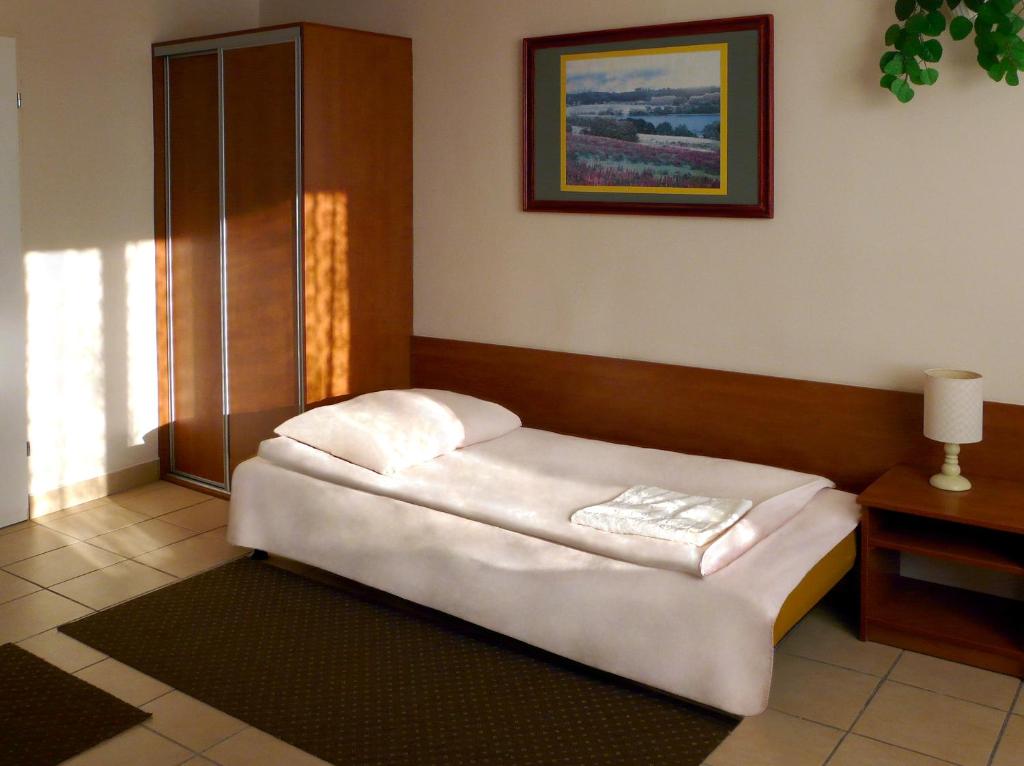 een klein bed in een kamer met een raam bij Hotel Turystyczny in Białystok