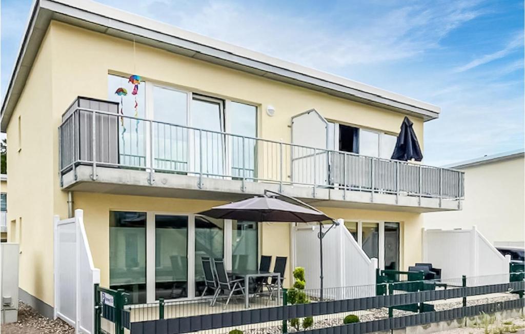 a house with a balcony and an umbrella at Lovely Apartment In Graal-Müritz in Graal-Müritz