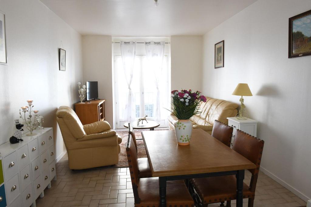 een woonkamer met een tafel en een bank bij L'albatros in Dieppe