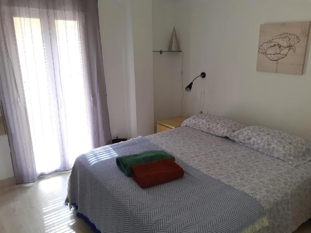 バレンシアにあるSmart Apartment near Malvarossa beachのベッドルーム1室(赤と緑のタオルが付いたベッド1台付)