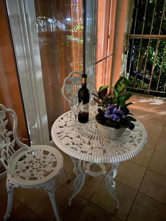 a white table with two chairs and a bottle of wine at SPA Apartament Sirius house in Saints Constantine and Helena
