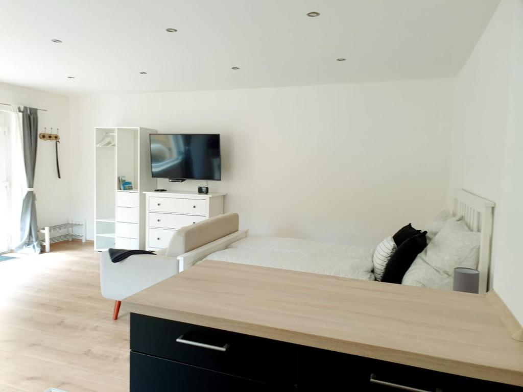 a bedroom with a bed and a dresser with a tv at Ferienwohnung im Green in Bad Neuenahr-Ahrweiler