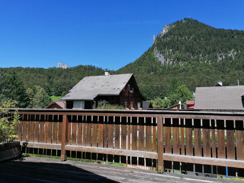 ein Gebäude mit einem Zaun mit einem Berg im Hintergrund in der Unterkunft Haus Tressenstein in Bad Aussee