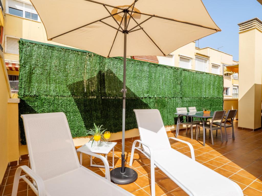 patio con sedie bianche e ombrellone di LA ALCAZABA - Exclusive Penthouse a Málaga