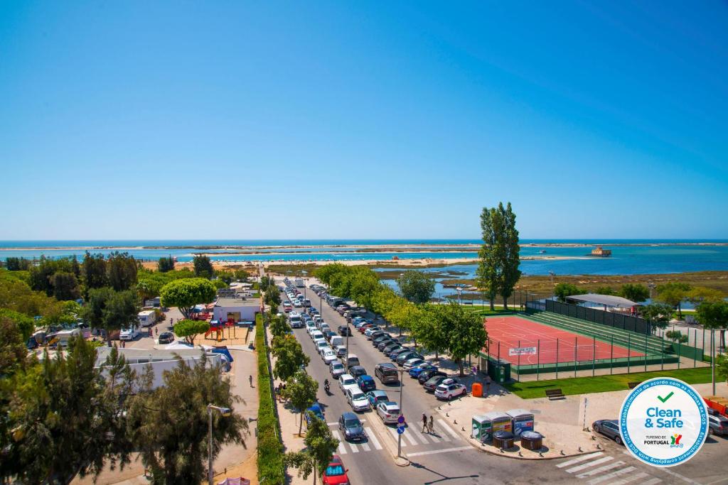 uma vista superior de um parque de estacionamento com carros estacionados em Apartamento Praia Fuzeta na Fuzeta