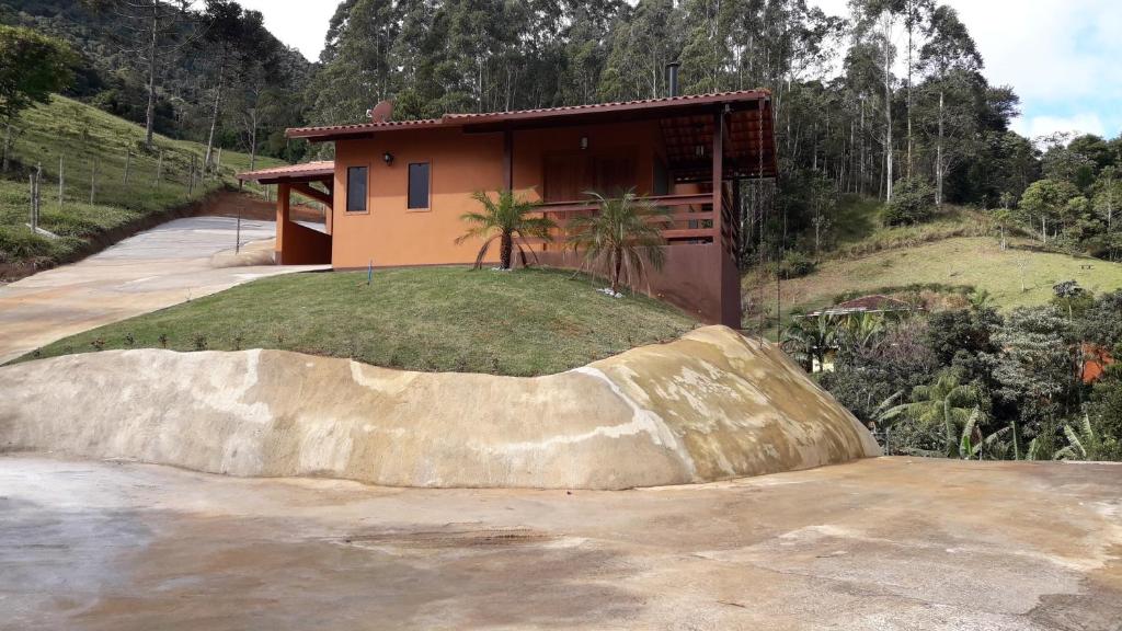 a house on top of a hill with a large rock at Pousada Recanto da Serra in São Pedro da Serra