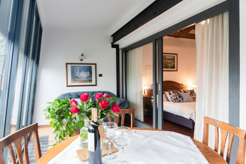 a dining room table with a vase of red roses at Aparthotel Hornigold "W Zielonej Kamienicy" in Katowice