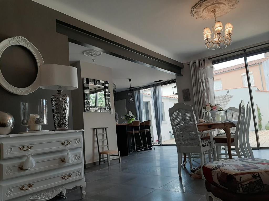 a living room with a white dresser and a table at Villa Raissa marché Arago et les plages in Les Sables-dʼOlonne