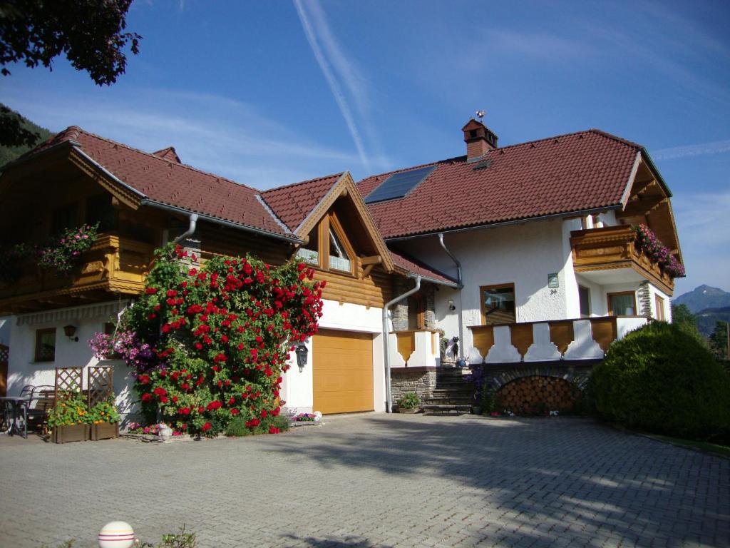 een huis met een bloeiende struik ervoor bij Apartment Haus Dengg in Mauterndorf