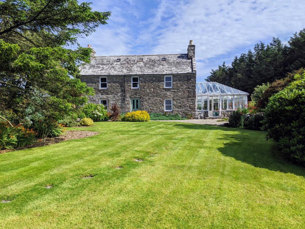 an old stone house with a large yard at Cosy, Coastal Retreat with a Large Garden in Monreith